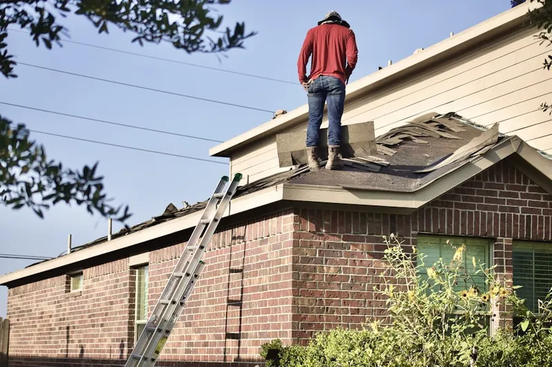 Professional roofer working on a residential roof in Albion